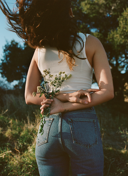 Woman in jeans holding flowers
