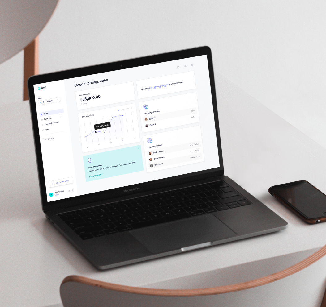 A laptop on a desk showing the Deel userface.