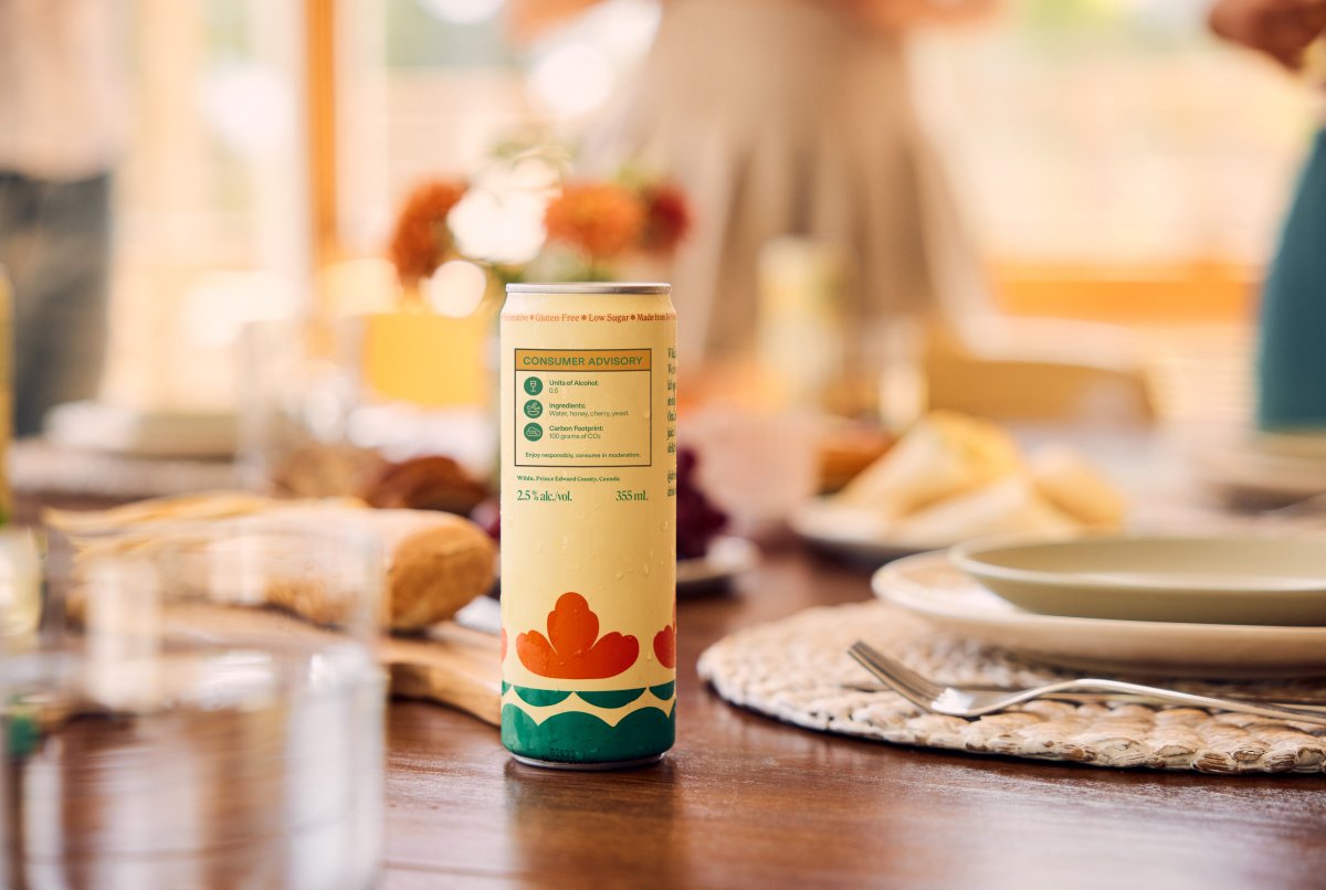 Can of alcohol on dinner table with advisory label on packaging.